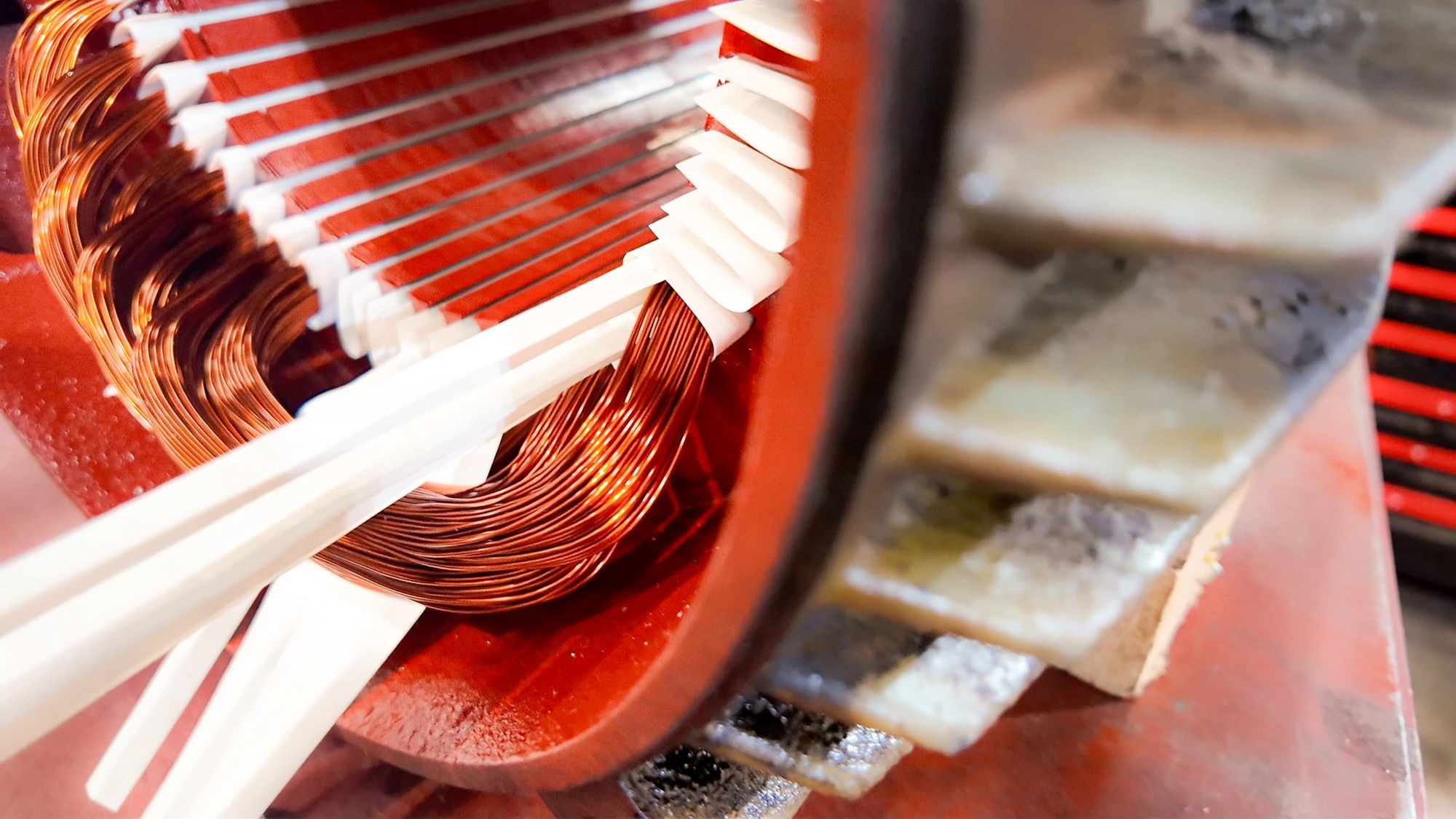 Close-up of a computer transformer with copper wiring and ceramic components showing inside, possibly part of an electronic device or power supply.